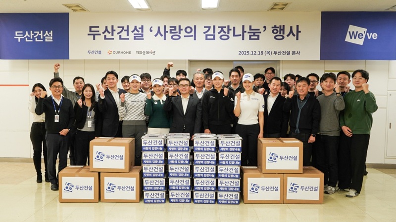 [사진1-두산건설] 김장을 끝내고 행사에 참여한 임직원과 골프단이 기념촬영을 하고 있다..jpg